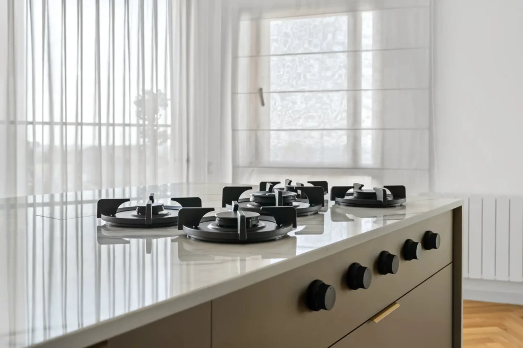 Bildkälla: Restyle XL PITT Cooking Elbrus gasbrännare black edition integrerade i ljus köksö med Front Side-vred